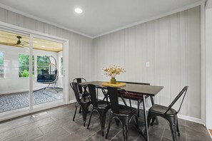 Un comedor con una mesa, sillas y un florero.