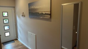 A hallway with a door, a radiator, and a framed picture on the wall.