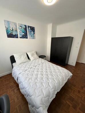 Una camera da letto con un letto, un tavolino rotondo e un armadio.
