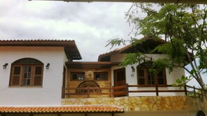 A two-story building with a stone facade, a wooden balcony, and a sign reading 'KITE AREA'. - Pousada Paracuru kite Village (Paracuru)