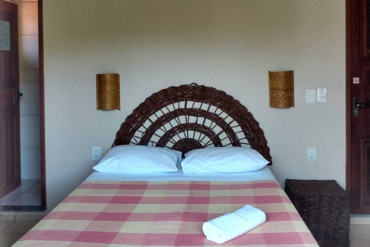 A room with a bed, a ceiling fan, and a checkered bedspread.
