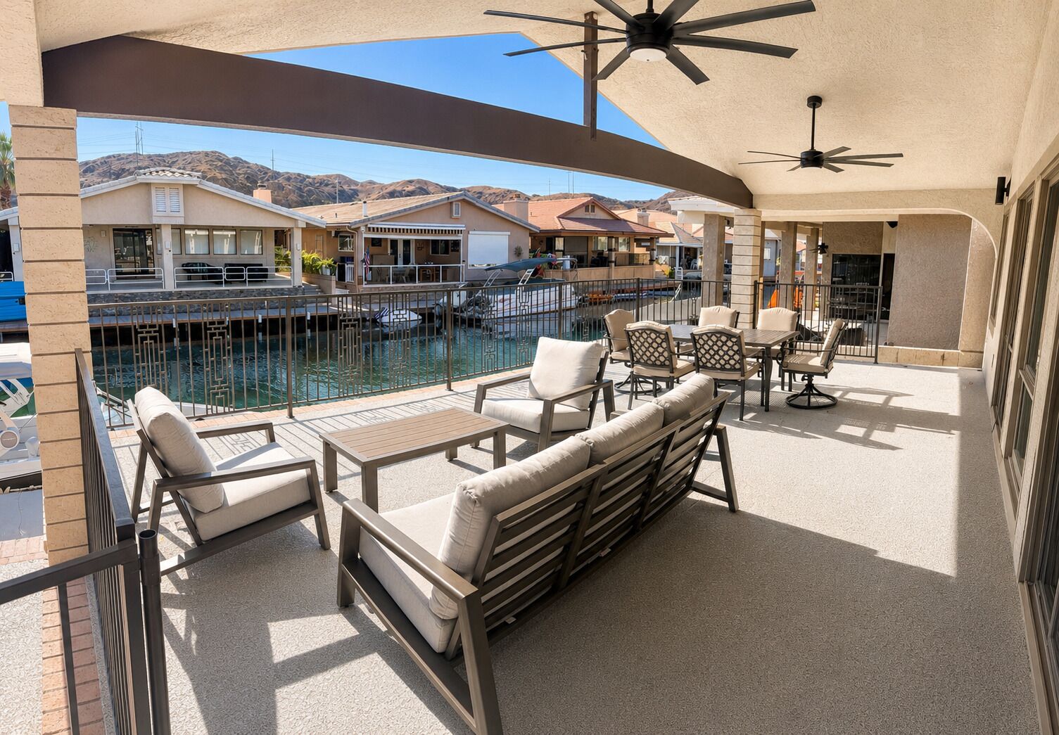 Un balcón con mobiliario exterior, piscina y vistas a una zona residencial.