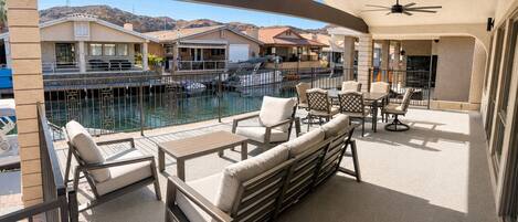 A balcony with outdoor furniture, a pool, and a view of a residential area.
