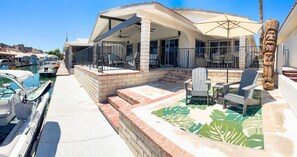 A waterfront property with a covered patio, outdoor seating, and a pool area. - The First Inn Parker Arizona (Parker)