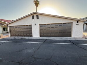 A two-car garage attached to a building with a beige exterior and a red roof. - The First Inn Parker Arizona (Parker)