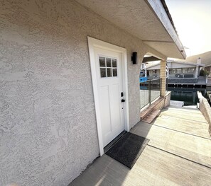 A white door with a window, a metal gate, and a concrete floor leading to a dock. - The First Inn Parker Arizona (Parker)