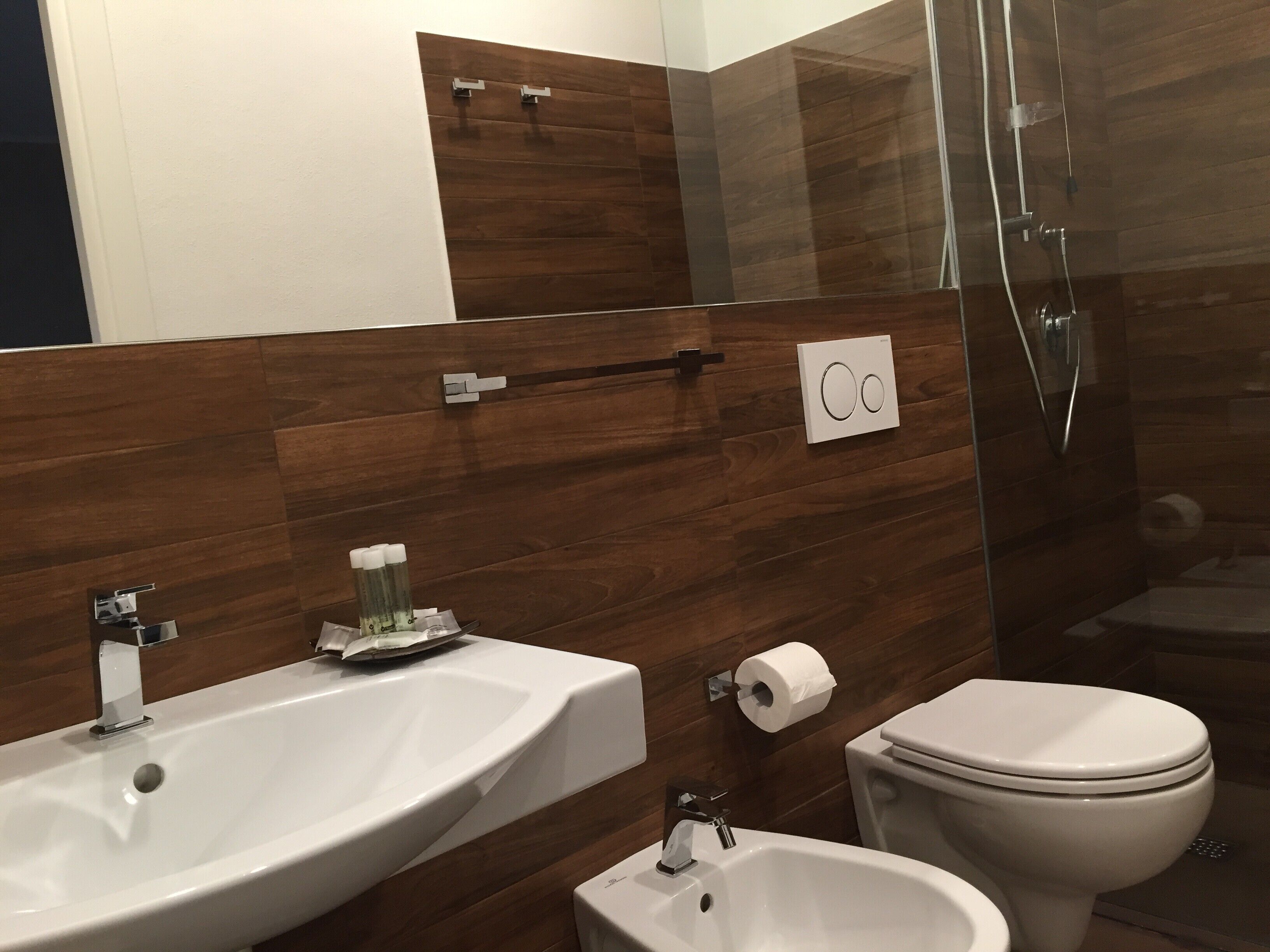 Een moderne badkamer met een grote wastafel, toilet en hygiëneslot.