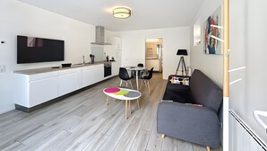 Eine moderne Wohnung mit Küche, Essbereich und Wohnzimmer.