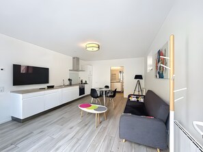 Moderni huoneisto, jossa on keittiö, ruokailutila ja olohuone.