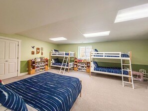 A room with bunk beds, a large bed, a ladder, and shelves with toys. - 71-Acre Private Nature Retreat & Curated Heirloom Home Near Turkey Run (Bloomingdale)