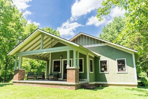 A green house with a covered porch, brick foundation, and two windows. - 71-Acre Private Nature Retreat & Curated Heirloom Home Near Turkey Run (Bloomingdale)
