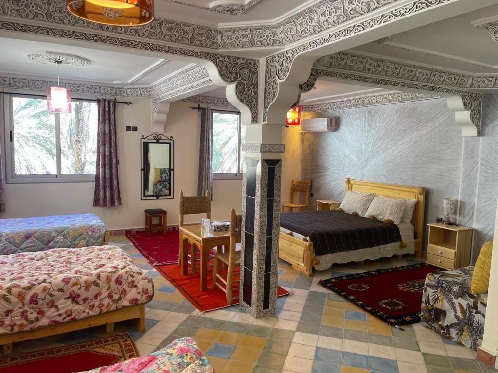 Una habitación con cama, una silla, una mesa y una ventana.