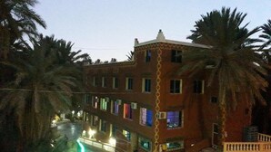 Un edificio de varios pisos con un diseño arquitectónico distintivo, que presenta un patio central y una serie de balcones.