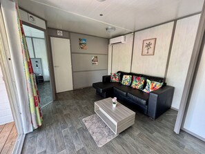 Un salon avec un canapé, une table basse et une petite plante.