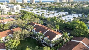 A residential area with multiple-story buildings, some with red-tiled roofs, surrounded by greenery and palm trees. - Port Royale Apartments (Fort Lauderdale)