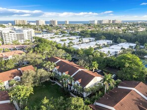A residential area with multiple-story buildings, some with red-tiled roofs, surrounded by greenery and palm trees. - Port Royale Apartments (Fort Lauderdale)