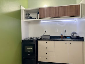 Eine kompakte Küche mit Gasherd, Backofen, Spüle und Arbeitsplatte.