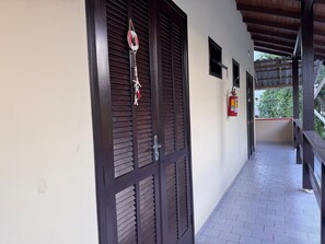 Ein Flur mit Holztür, Feuerlöscher und kleinem Fenster.