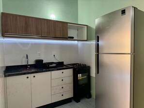 Eine Küche mit Kühlschrank, Herd und Schränken.