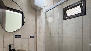 A small bathroom with a sink, mirror, and toilet. - 02 | Res. 305 • Cozy Apartment for Couple – 5min from the Beach (Bombinhas)