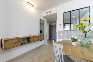 Ein moderner Essbereich mit Holztisch, weißen Stühlen, einer eingebauten Ablagefläche und einem großen Fenster.