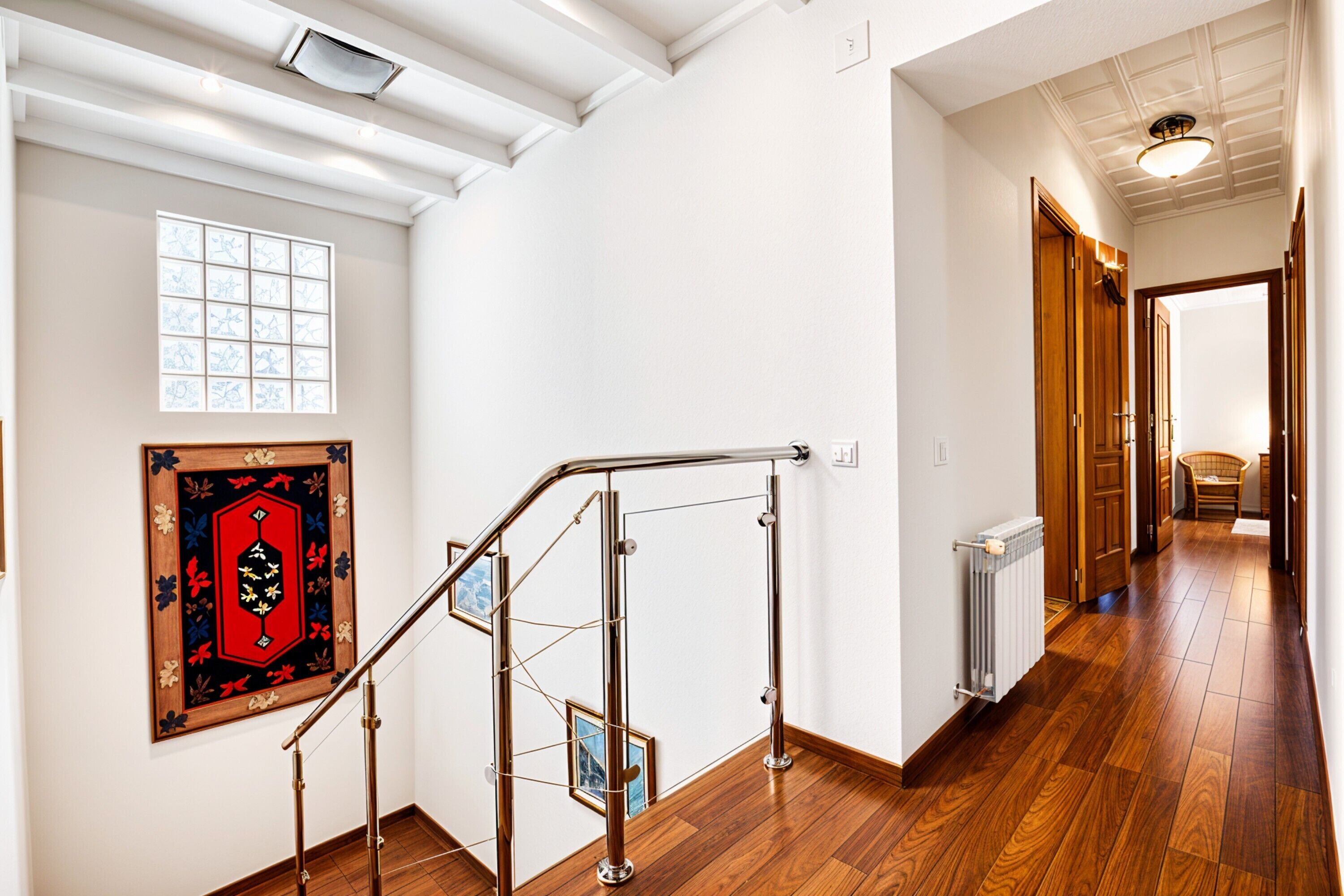 Eine Treppe mit Metallgeländern, Holzdielen, einem Heizkörper und einem gerahmten Kunstwerk an der Wand.