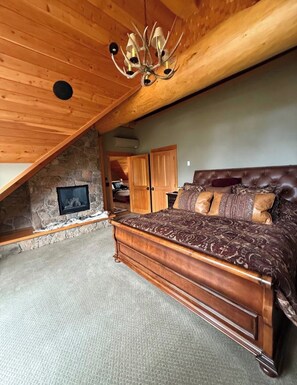 Ein Schlafzimmer mit Holzboden, einer Steinwand, einem Bett und einem Fernseher.