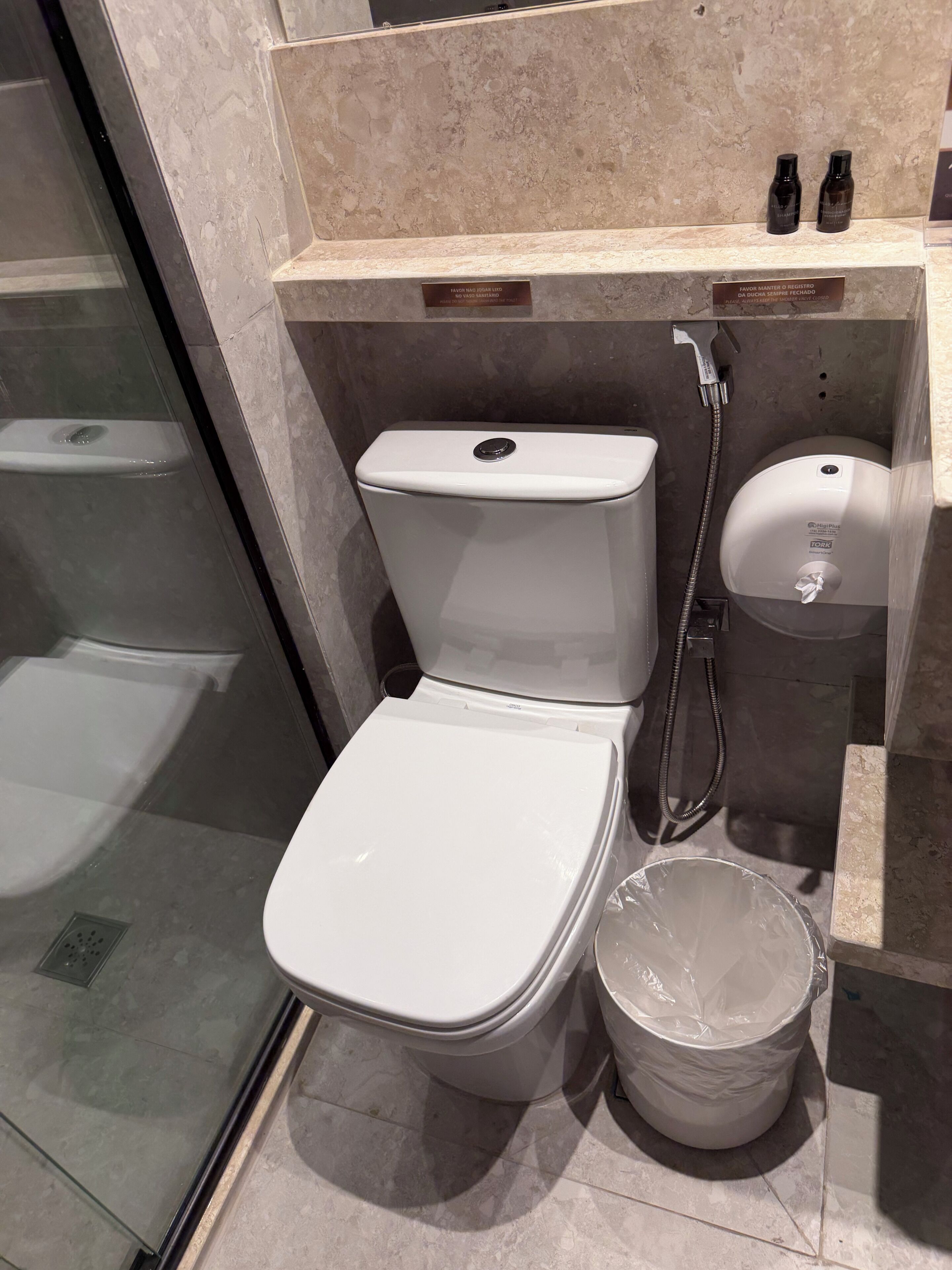 Ein modernes Badezimmer mit Toilette, Bidet und einer Duschkabine aus Glas.