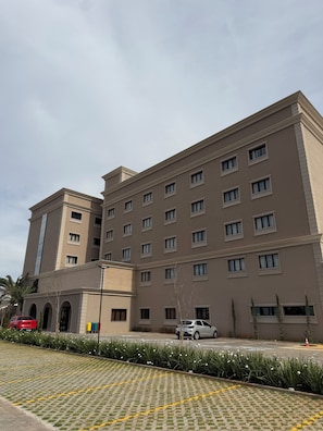 A multi-story hotel with a symmetrical facade, evenly spaced windows, and a flat roof. - Class Hotel Americana (Americana)