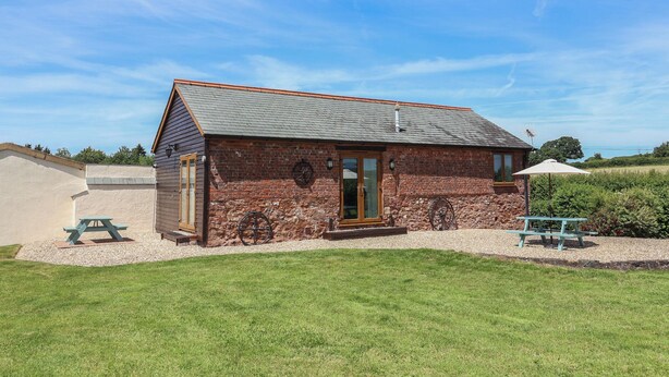 A rustic building with a stone facade, a wooden door, and a small porch. - Little Owl Barn (Wellington)