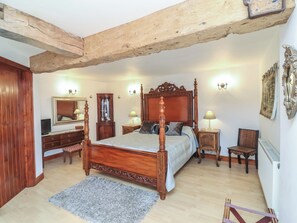 A bedroom with a four-poster bed, wooden furniture, a mirror, and wall sconces. - Little Owl Barn (Wellington)