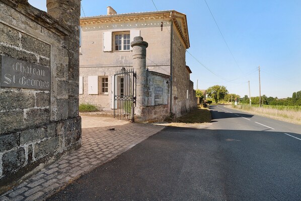 Un edificio con un letrero que dice 'Chateau St Georges' y una entrada con rejas.