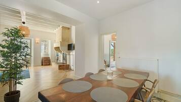 Un comedor con una mesa de madera, sillas y una planta en maceta.