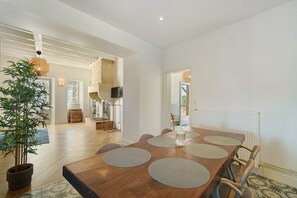 Un comedor con una mesa de madera, sillas y una planta en maceta.
