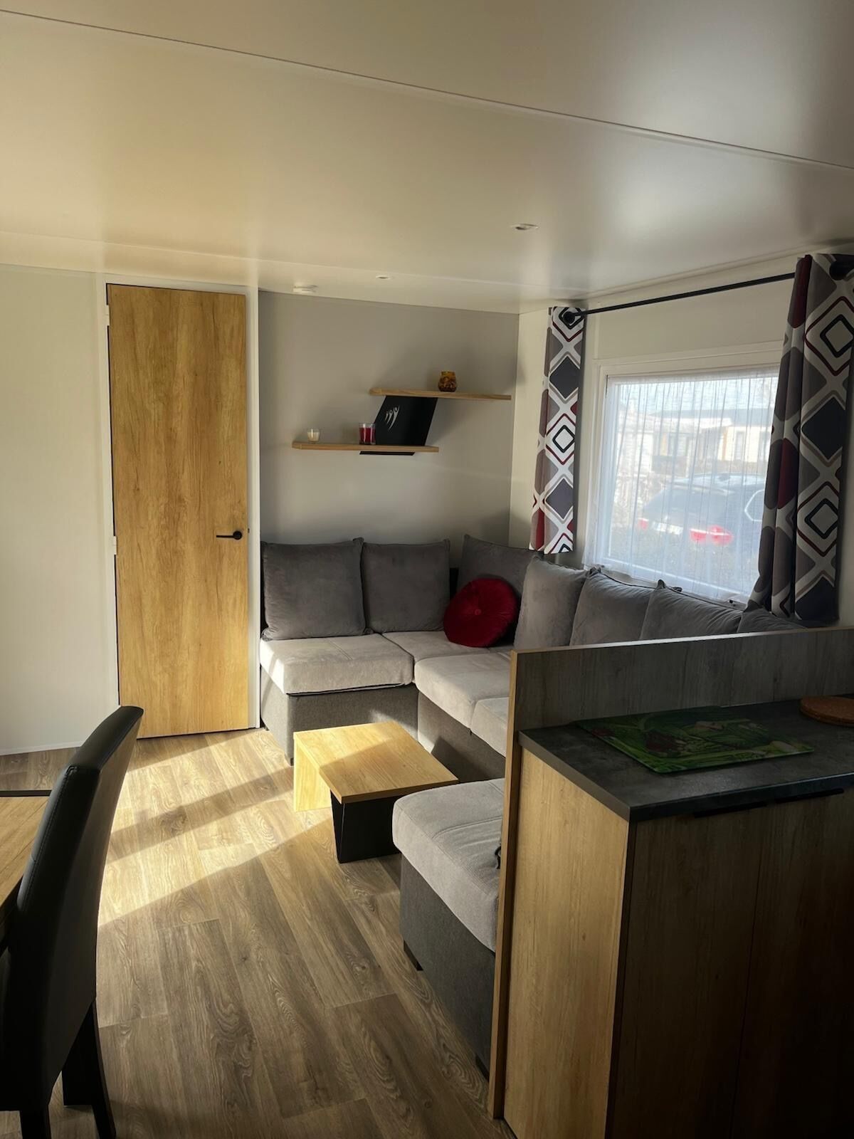 Un salon moderne avec un canapé, une table à manger et une porte en bois.