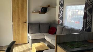 Un salon moderne avec un canapé, une table à manger et une porte en bois.
