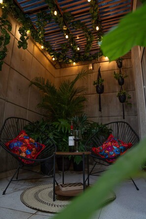 A cozy seating area with two chairs, a small table, and a bottle of wine. - Condesa 2Terraces Apartment walking to parks w/AC (Mexico City)