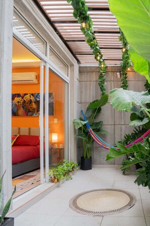 A modern patio with a hammock, potted plants, and a colorful artwork on the wall. - Condesa 2Terraces Apartment walking to parks w/AC (Mexico City)