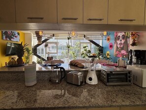 Eine Küche mit Granit Arbeitsplatten, einem Toaster, einem Mixer, einer Kaffeemaschine und einem Elektrobackofen.