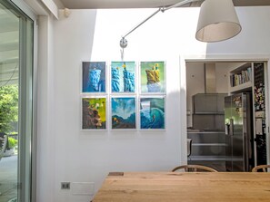 Eine moderne Küche mit einem Edelstahlkühlschrank, einem Holztisch und einer Wandleuchte.
