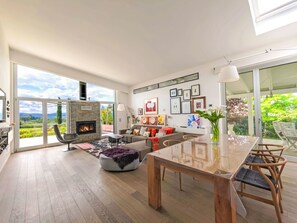 A spacious living area with a fireplace, a dining table, and a sofa. - Mulberry Garden by Interhome (Belvedere Ostrense)