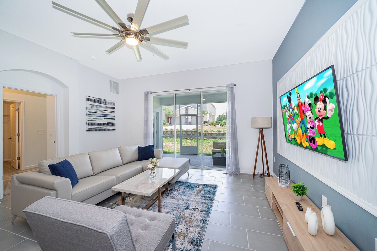 A modern living room with a sofa, coffee table, and TV.