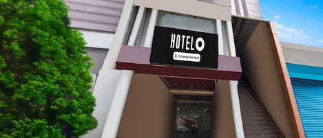 A hotel building with a sign reading 'HOTEL O' and 'Company-Serviced.'