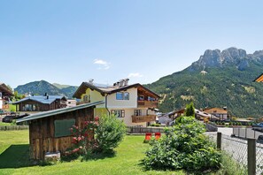 A mountain village with traditional wooden houses, a small wooden structure, and a view of the surrounding mountains. - Apartment 'Roda De Vael' with Mountain View, Balcony and Wi-Fi (Vigo di Fassa)