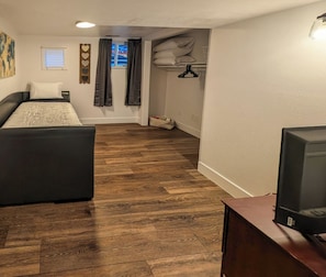 Un dormitorio con cama, televisor y armario.