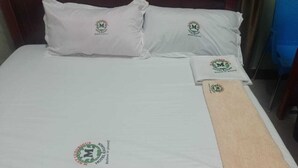 Una cama con almohadas y una manta, cada una con un logotipo.