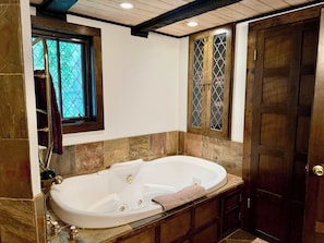 A bathroom with a freestanding bathtub, a window with a view, and a wooden door. - Tynecastle Retreat - Views, Game Room & Patio (Banner Elk)