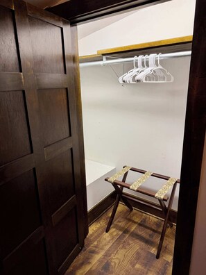 A wooden wardrobe with a mirror, a hanging clothes rack, and a small wooden table. - Tynecastle Retreat - Views, Game Room & Patio (Banner Elk)