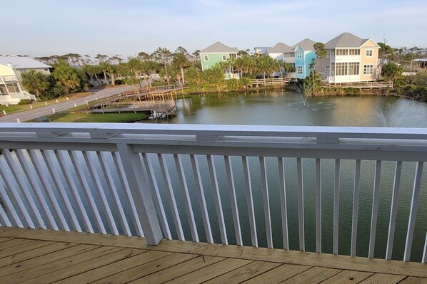 A waterfront property with a wooden deck, a bridge, and houses with gabled roofs. - Dog-Friendly End Unit· Gulf Views· 1 Min to Beach (Port St Joe)