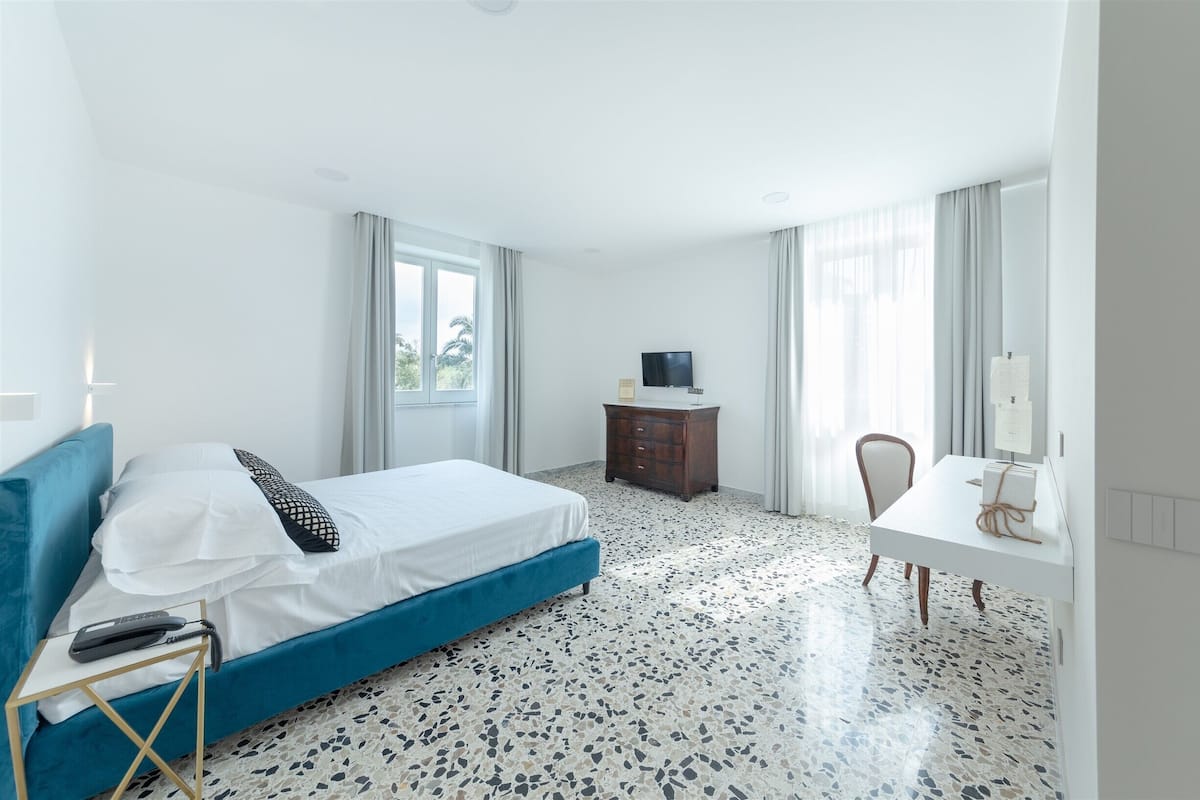 Een hotelkamer met een bed, een bureau, een televisie en een raam.